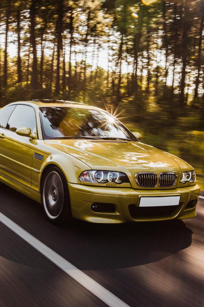 BMW driving with forest in the background