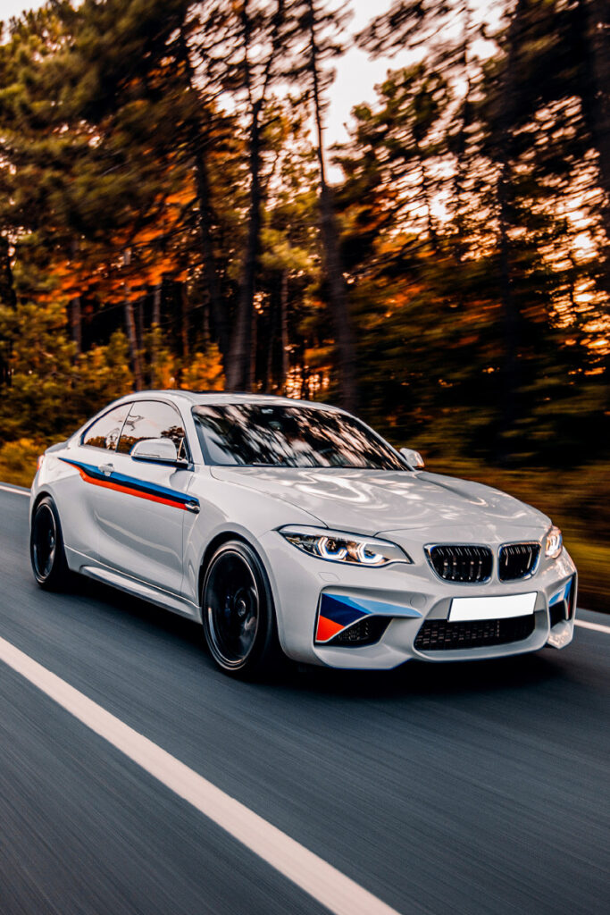 BMW driving down road in the sunset