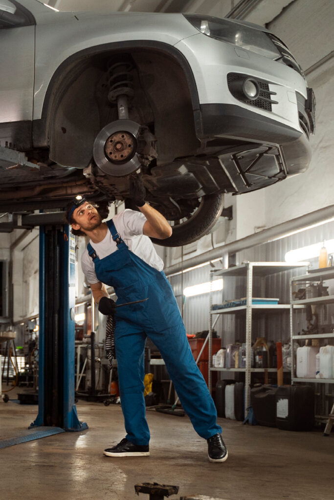 Mechanic inspecting underneath car