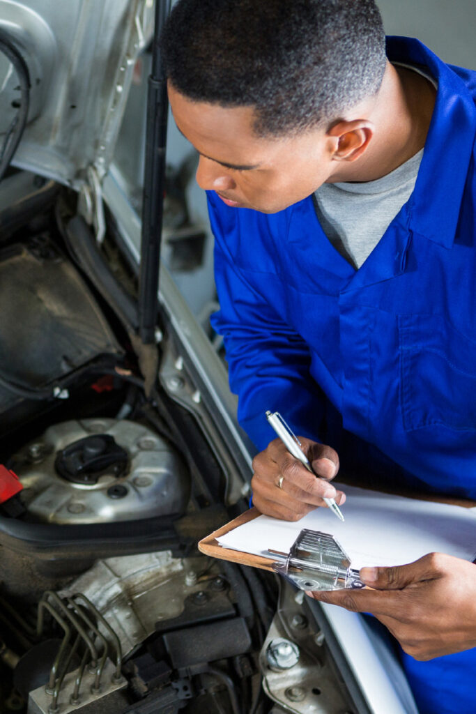 Mechanic inspecting engine bay of car