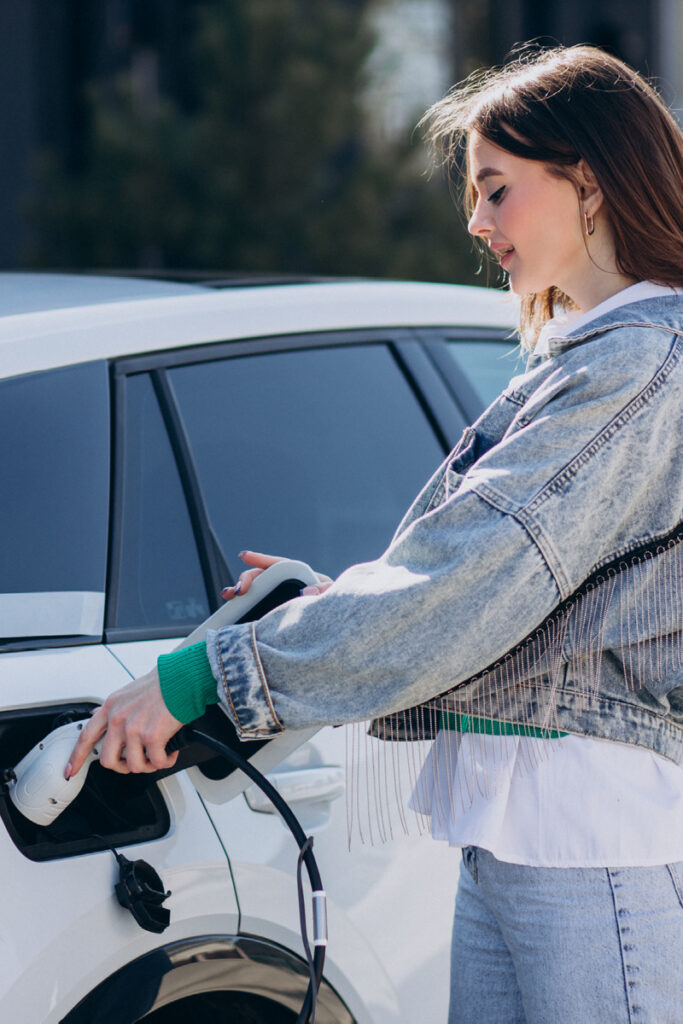 Female plugging in ev car to charging point