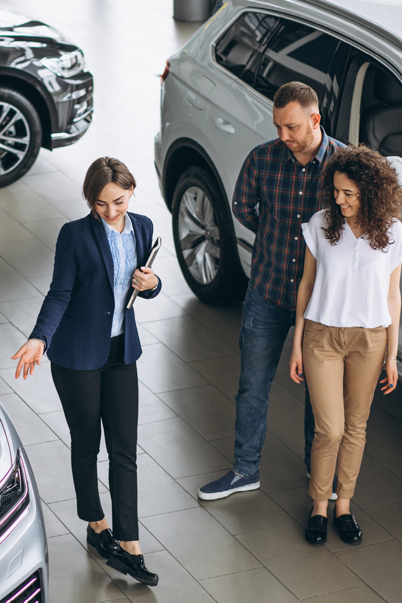 Sales rep showing customers a new car