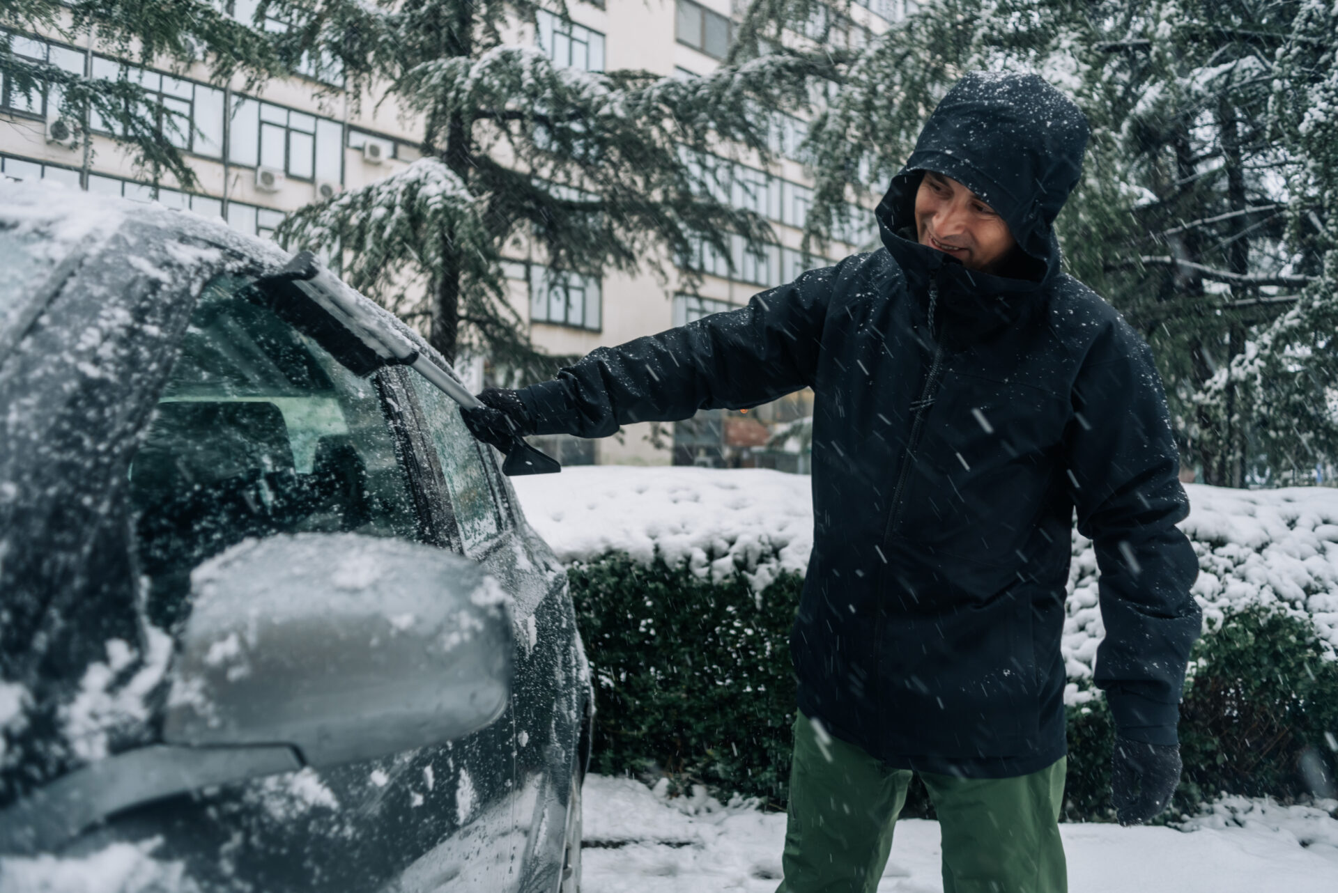 Middle aged man cleaning car from snow and ice | Warrantywise