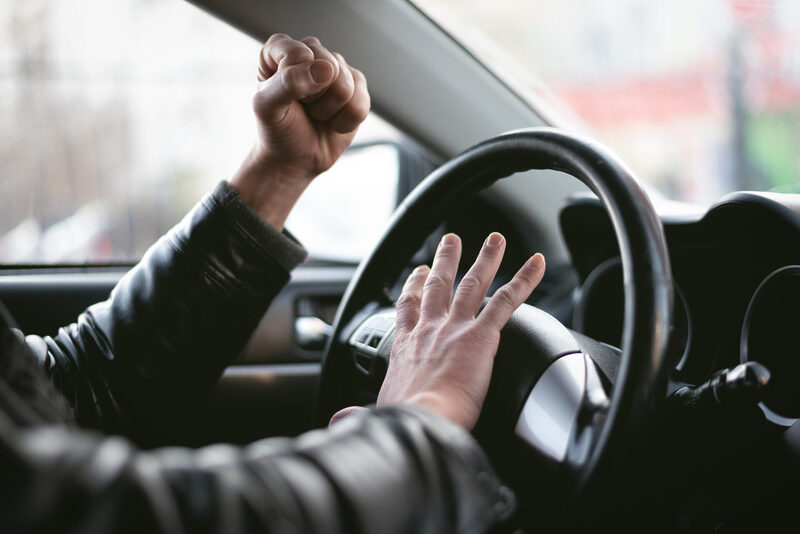 Angry driver sat in car honking on horn