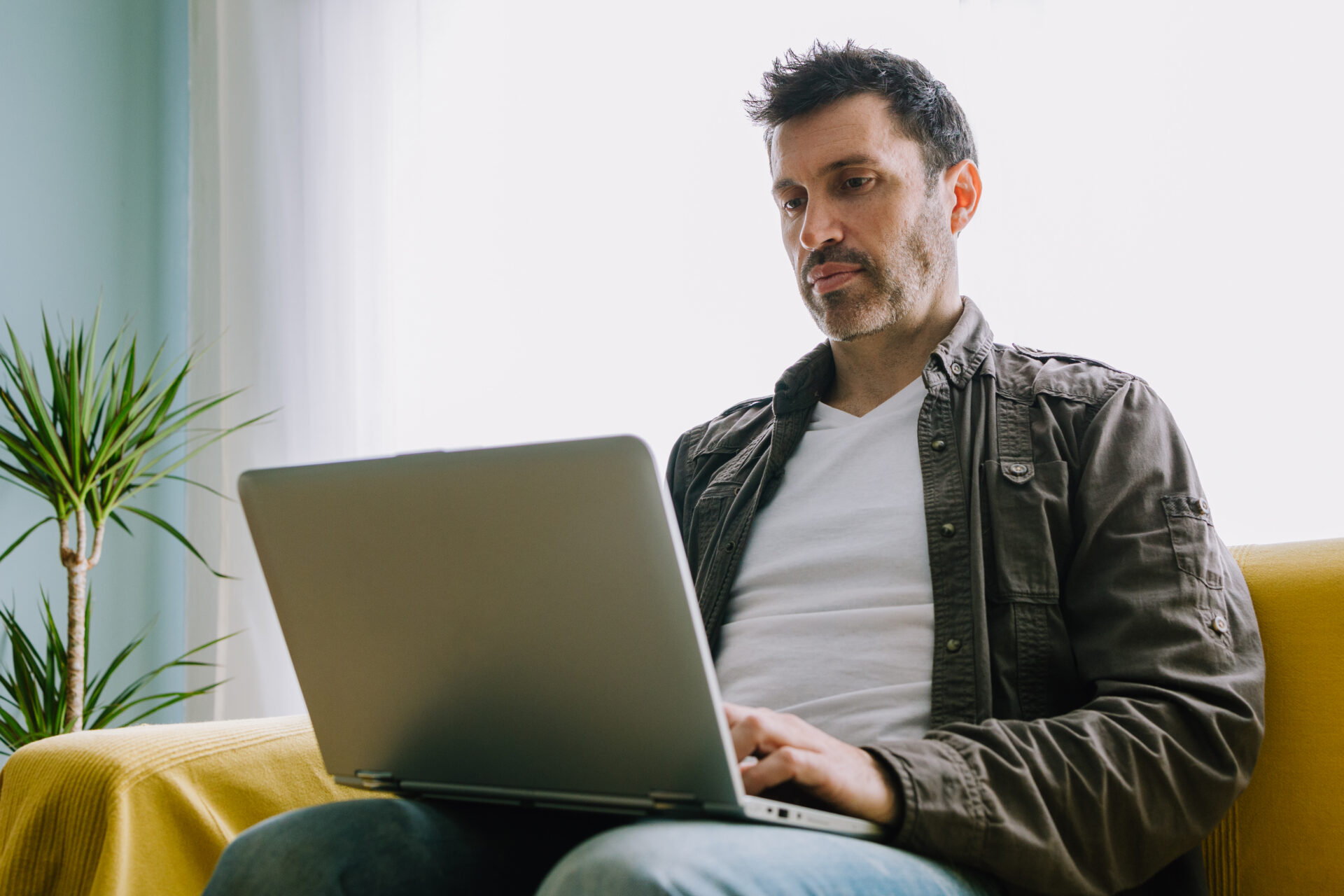 Young man working from the sofa at home | Warrantywise