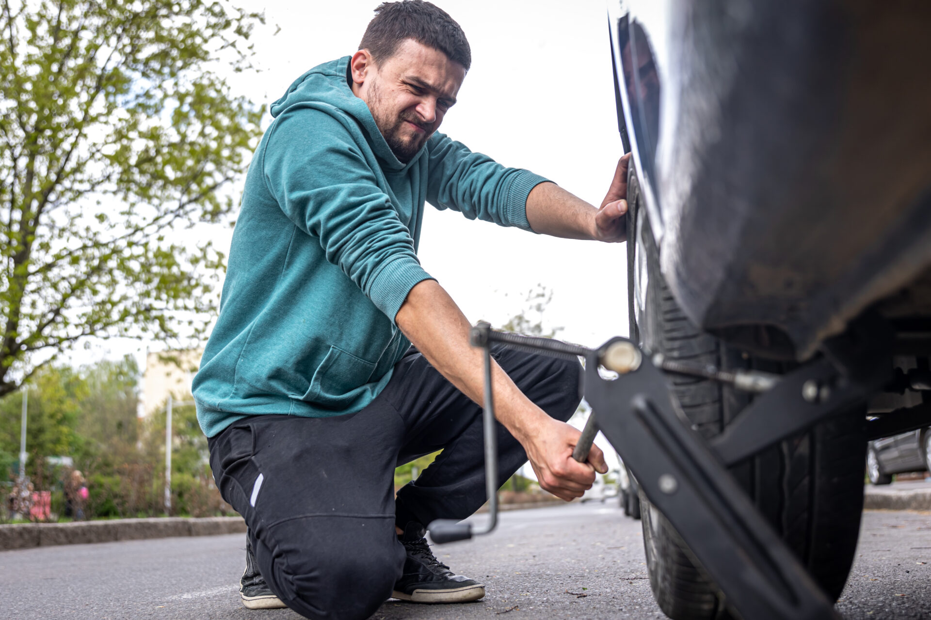 A male driver changes the wheel of a car on the road | Warrantywise
