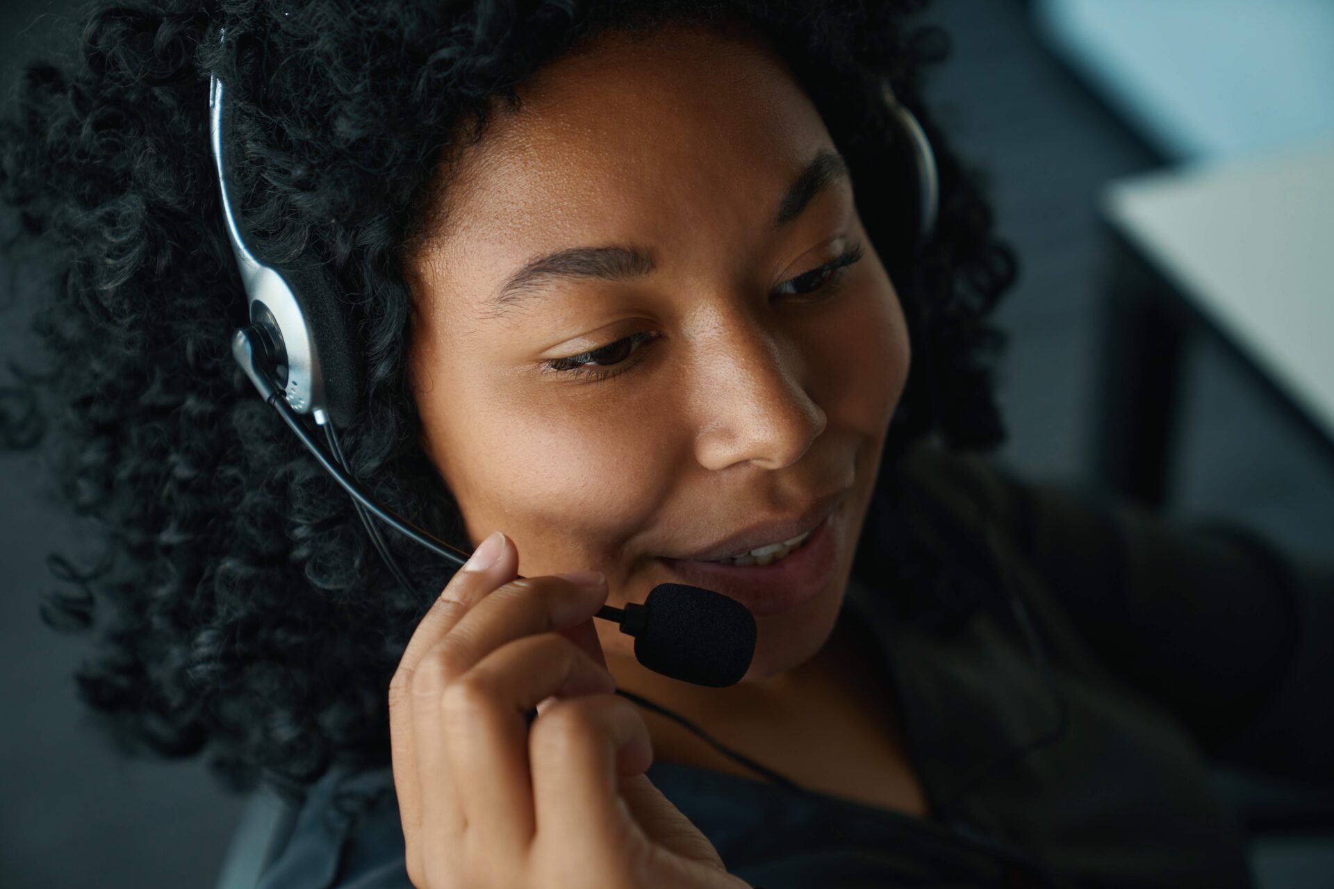 Pleasant woman is talking through mobile headset | Warrantywise young woman talking on telephone headset